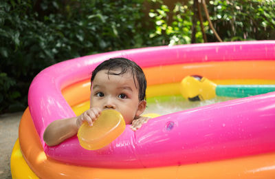 Portrait of cute boy playing in wading pool