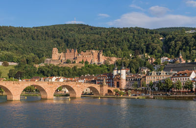 Arch bridge over river against buildings