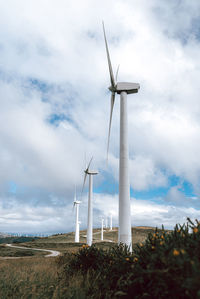 Low angle view of windmill on field against sky