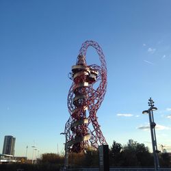 Low angle view of ferris wheel against clear blue sky