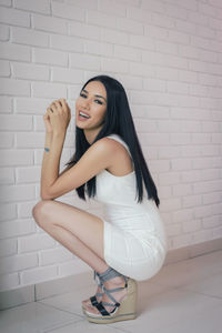 Portrait of smiling woman against wall