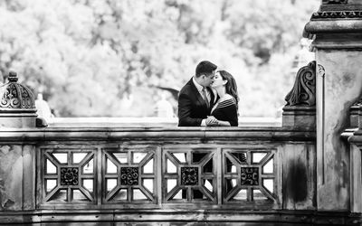 Couple kissing by railing on footbridge