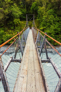 High angle view of footbridge over river against trees at forest