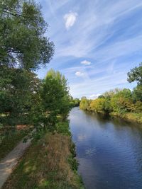 Scenic view of river amidst trees against sky