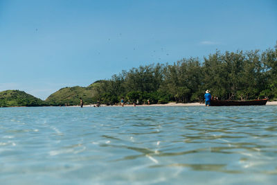 People in sea against sky