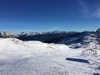 Snow covered mountains against clear blue sky