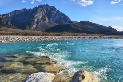 Scenic view of sea and mountains against sky