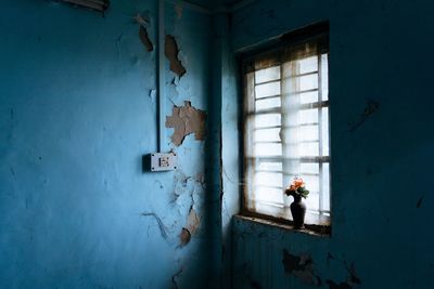 Man standing by window of abandoned building