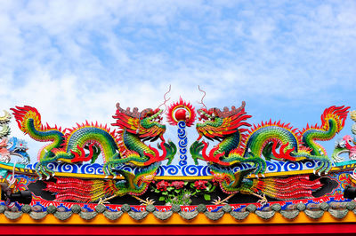 Low angle view of multi colored statue in temple against sky