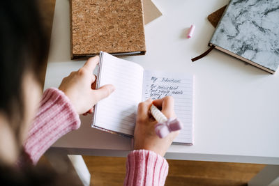 Cropped hand of woman holding paper