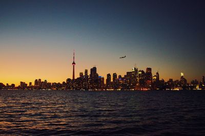 View of city at waterfront during sunset