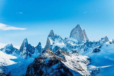 Scenic view of snowcapped mountains against blue sky