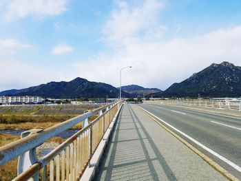 Road by mountain against sky