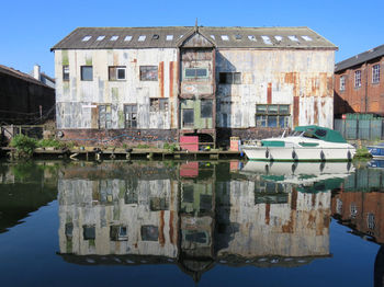 Reflection of buildings in lake against clear sky