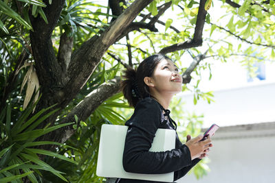 Woman in a black dress holds a laptop computer. the concept of young entrepreneurs.