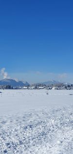 Scenic view of snowcapped mountains against blue sky