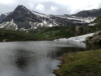 Scenic view of snowcapped mountains against cloudy sky