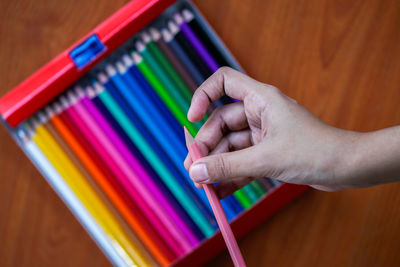 A girl getting ready for a new school season with her sharpened multi coloured pencil