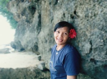 Portrait of smiling boy standing on rock