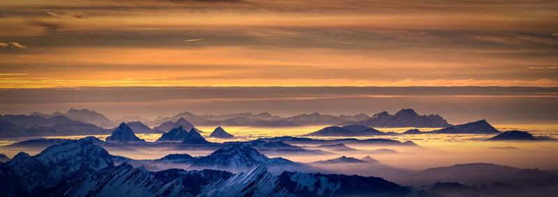 Scenic view of snowcapped mountains against sky during sunset