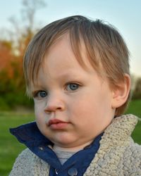 Close-up portrait of cute boy on field