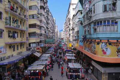 People on street amidst buildings in city