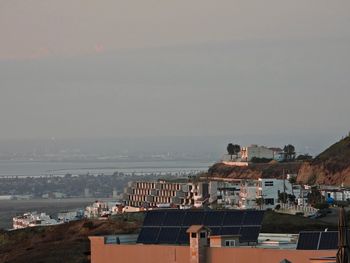 High angle view of townscape by sea against sky