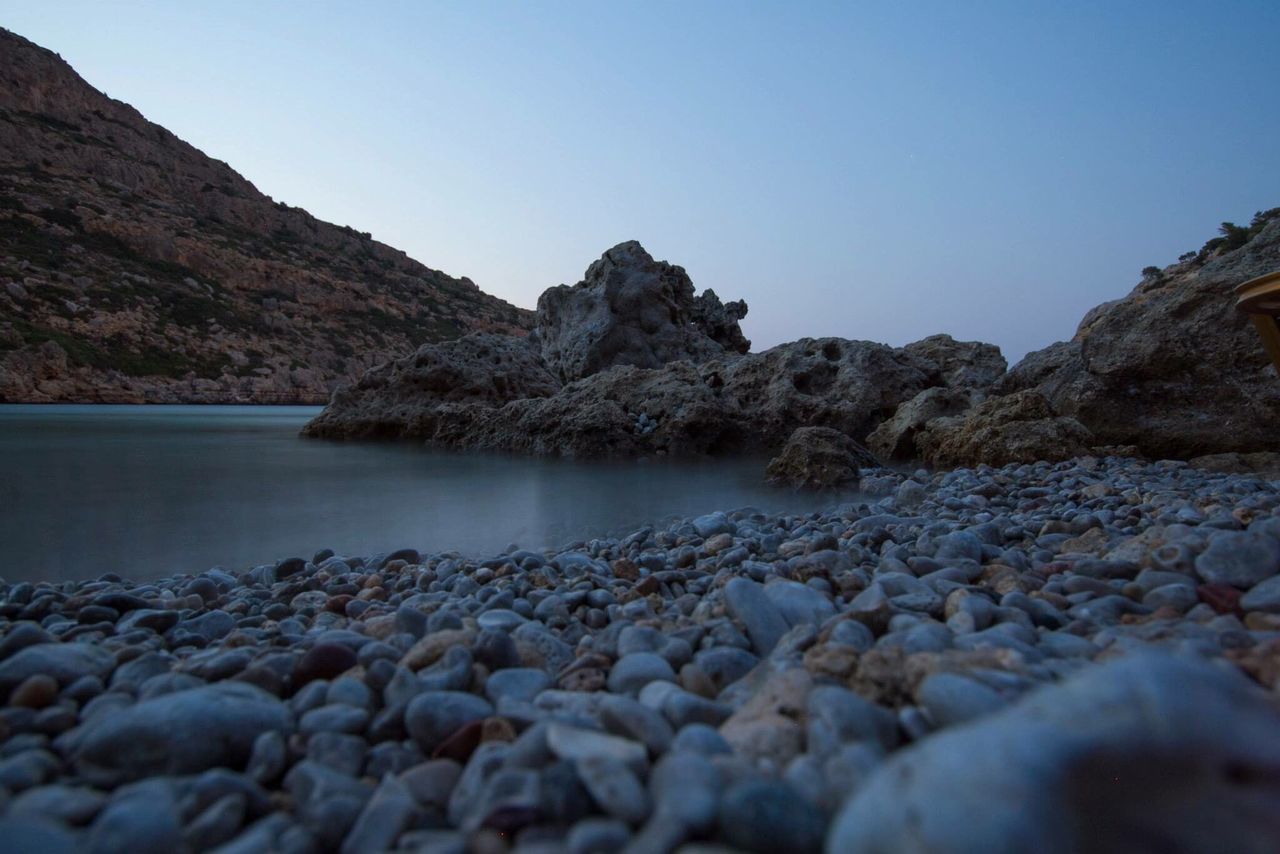 water, nature, beauty in nature, pebble, sea, surface level, no people, beach, sky, tranquility, pebble beach, tranquil scene, clear sky, day, scenics, outdoors