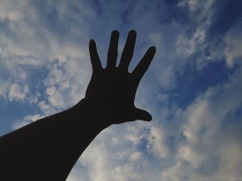 Low angle view of silhouette hand against sky