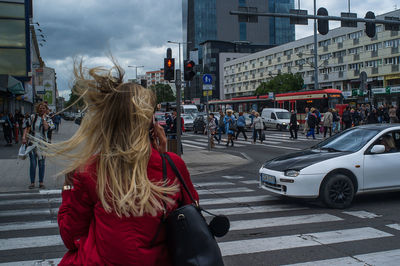 People on street in city against sky