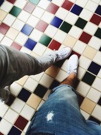 Low section of man on tiled floor