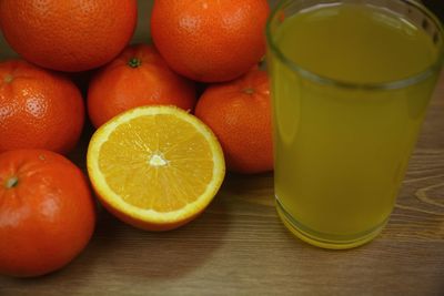 High angle view of orange fruits and juice in glass on table