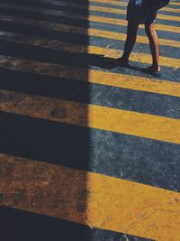 Low section of person walking on road