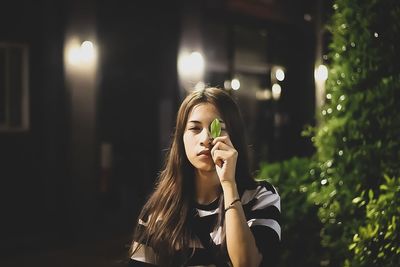 Portrait of young woman in illuminated traditional clothing outdoors