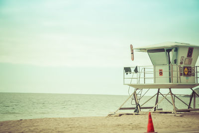 Lifeguard hut on beach against sky