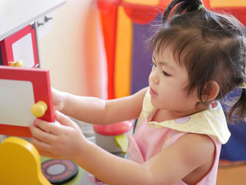 Cute girl playing with toy at home