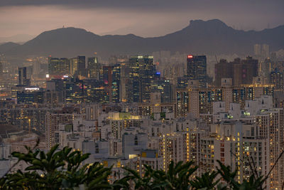 Illuminated buildings in city against sky