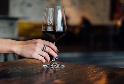 Close-up of hand holding drink on table