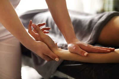 Therapist massaging hands at spa