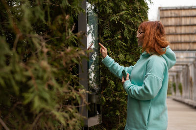 Rear view of woman standing against plants