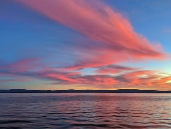 Scenic view of sea against dramatic sky during sunset