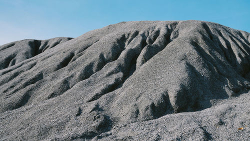 Low angle view of sand dune against sky