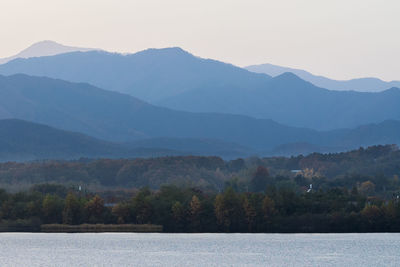 Scenic view of lake and mountains against clear sky