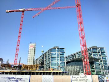 Low angle view of crane against blue sky