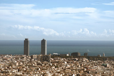 Scenic view of sea by buildings against sky