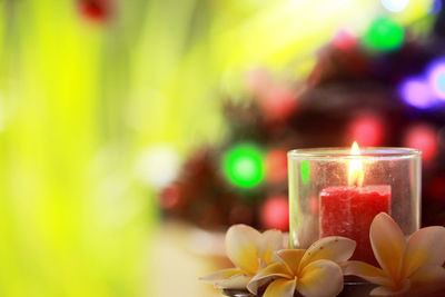 Close-up of lit candles on glass