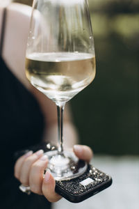 Midsection of woman holding wineglass