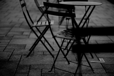 Empty chairs and table at sidewalk cafe