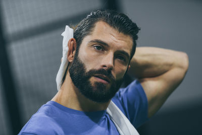 Man wipes sweat after a training session. sporty boy after match. sweaty athlete with towel in hand