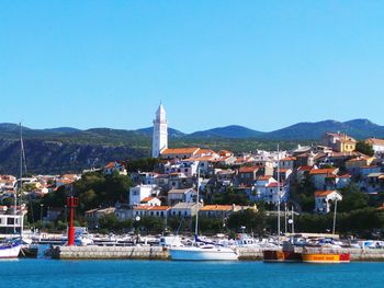 Adriatic sea by houses against clear blue sky at novi vinodolski